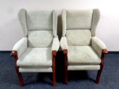 A pair of wingback armchairs in beige fabric