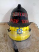 A Royal Air Force fireman's helmet together with a further vintage fireman's helmet