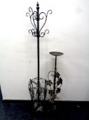 A wrought iron umbrella and coat stand and a wrought iron plant stand with leaf and grape