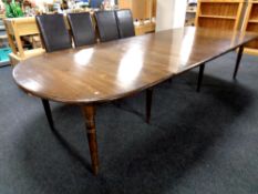 A stained pine flap end dining table with six extension leaves,
