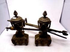 A pair of 19th century brass and cast iron fire dogs together with a toasting fork and three fire