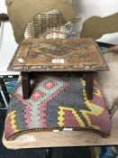 An antique carved oak footstool together with a further arched footstool upholstered in a tapestry