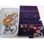 A basket containing a small quantity of costume jewellery, silver bangle, dress rings,