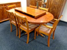 An eight piece inlaid yew wood dining room suite comprising of triple door sideboard fitted three