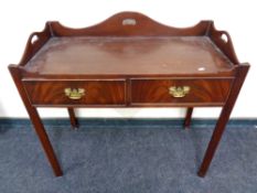 A two drawer side table with gallery on raised legs,