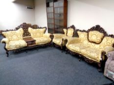 A three piece wood framed Rococo style lounge suite upholstered in gold fabric comprising two