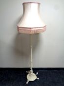 A cast iron painted standard lamp with tasseled shade