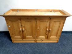 A pine four door wall cabinet,