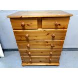 A contemporary pine five drawer chest