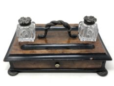 A Victorian walnut and ebonised desk standish with two cut glass inkwells