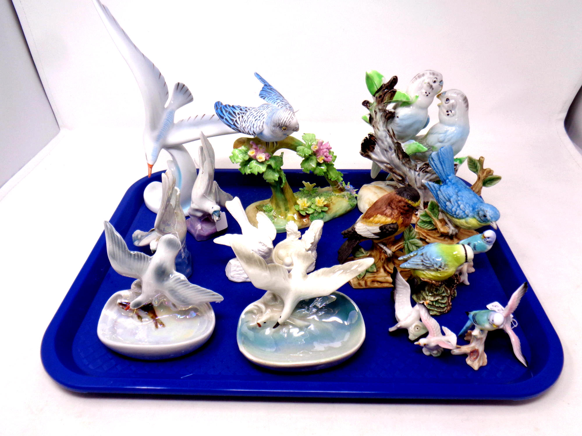 A tray containing a collection of porcelain bird ornaments