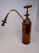 An antique copper and brass pump sprayer