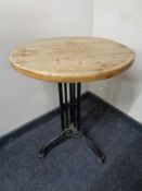 A circular pine topped bar table on cast iron Art Deco base