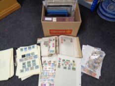 A box of stamp albums and folders containing 20th century world stamps and loose stamps