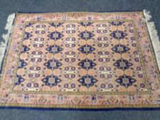 A woolen rug of geometric design on blue ground,
