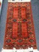 An Afghan style rug on red ground,