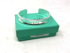 A Tiffany & Co silver bangle, boxed. CONDITION REPORT: 36.