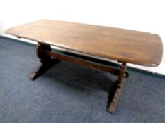 An Ercol solid elm and beech refectory dining table in an antique finish,