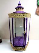 A Moroccan style metal and glass hexagonal display cabinet upholstered in a purple velvet fabric,