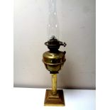 An antique brass Corinthian column oil lamp with glass chimney, height 69.
