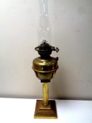 An antique brass Corinthian column oil lamp with glass chimney, height 69.