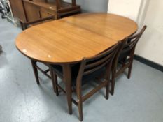 A 20th century oval teak extending dining table together with a set of four ladder back chairs