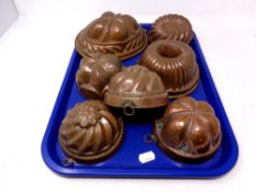 A tray containing seven antique copper jelly moulds