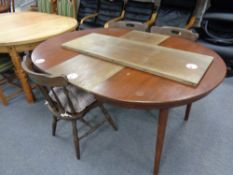 A circular 20th century extending kitchen table with two leaves together with a set of four stick
