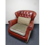 A red button leather and cloth wingback armchair