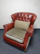 A red button leather and cloth wingback armchair