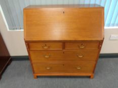 A mid 20th century teak fall front bureau fitted four drawers beneath,