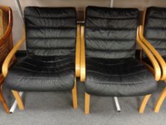A set of three beech framed armchairs with black leather cushions