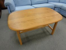 An oval blonde oak refectory coffee table,
