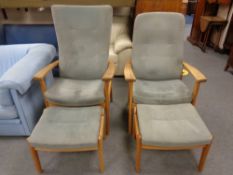 A pair of contemporary oak framed armchairs upholstered in a grey fabric with matching footstools