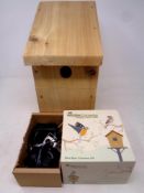 A wooden bird box together with two wildlife cameras
