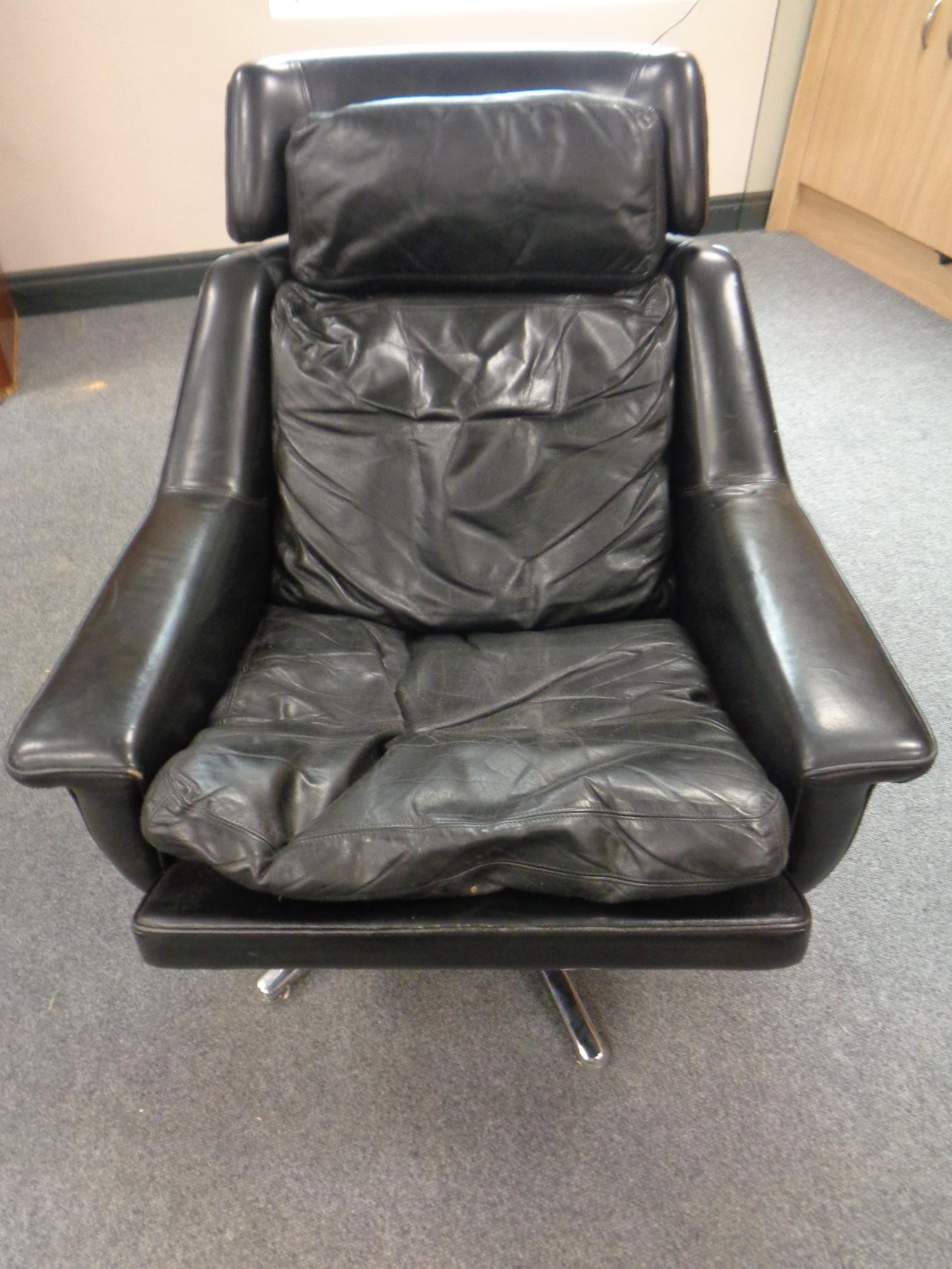 A 20th century black leather armchair on chrome legs