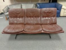 A 20th century Danish brown leather three seater settee on chrome metal legs