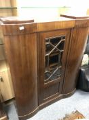 A continental triple door cabinet with glazed central panel door,