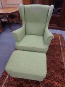 A contemporary wingback armchair with matching footstool upholstered in a green fabric