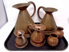 A tray containing four antique copper jugs together with a pair of copper embossed vases