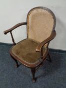 A 20th century beech bergere backed armchair