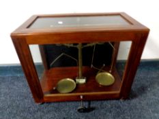 An antique set of brass chemist's scales in a display case
