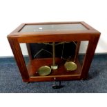 An antique set of brass chemist's scales in a display case