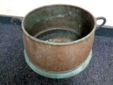 An antique copper twin handled cooking pot,