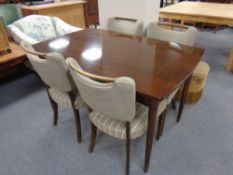 A 20th century extending dining table together with four chairs in a walnut finish