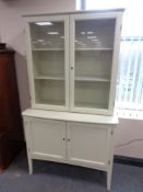 A 20th century Asko Furniture glazed door bookcase fitted cupboard beneath on raised legs (white),