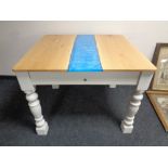A contemporary oak topped dining table with a resin inset panel on a painted base
