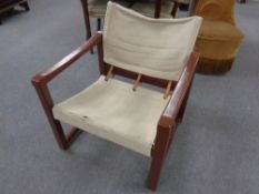 A painted wood framed armchair with canvas seat