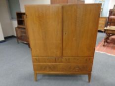 A mid 20th century continental double door cabinet fitted three drawers beneath on raised legs,