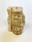 A Japanese carved bone netsuke - village elder with basket at his feet